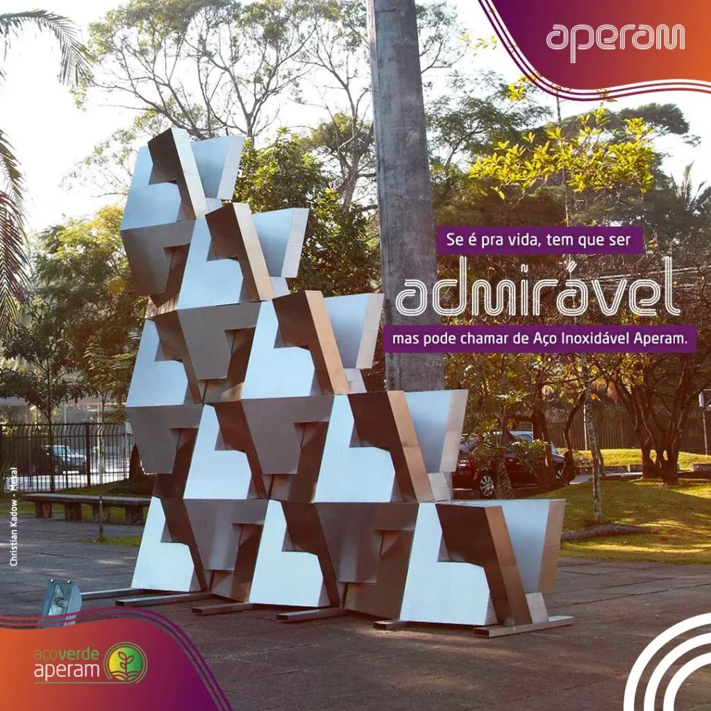 Admirável: aplicação da campanha sobre uma escultura pública em aço inoxidável já existente, reposicionando uma obra real como prova viva do material.
